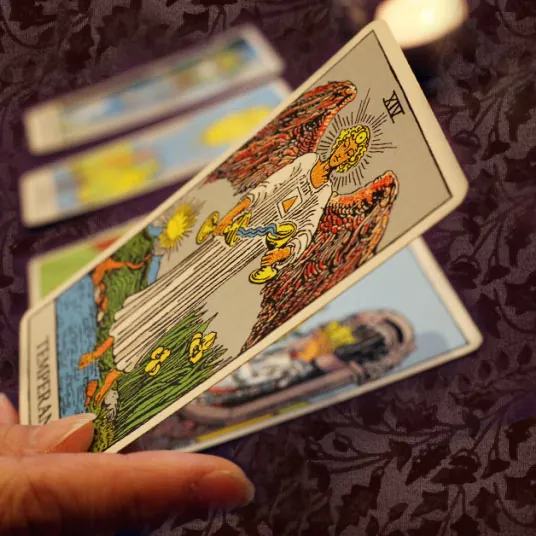 Mano sosteniendo la carta de la Templanza en una tirada de tarot