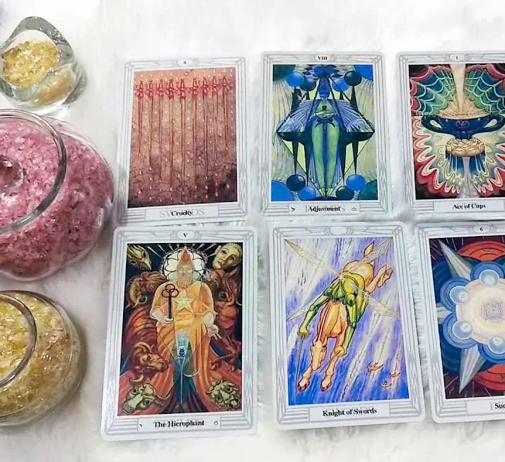 Cartas del tarot Thoth sobre piel blanca con sales rosas